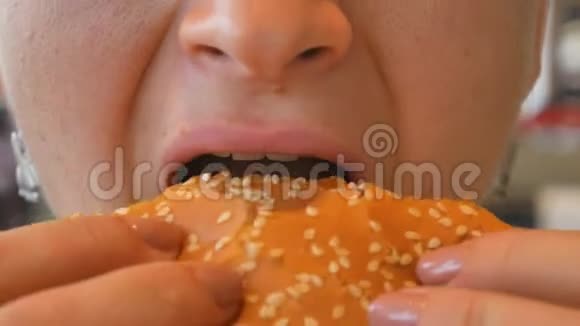 吃汉堡包的女孩特写镜头吃快餐女性手中的汉堡视频的预览图
