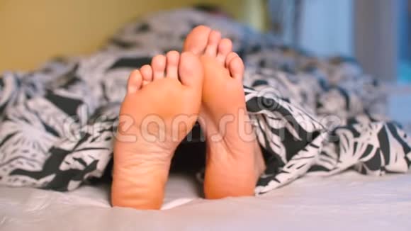 床上双脚特写腿从被子下面伸出来视频的预览图