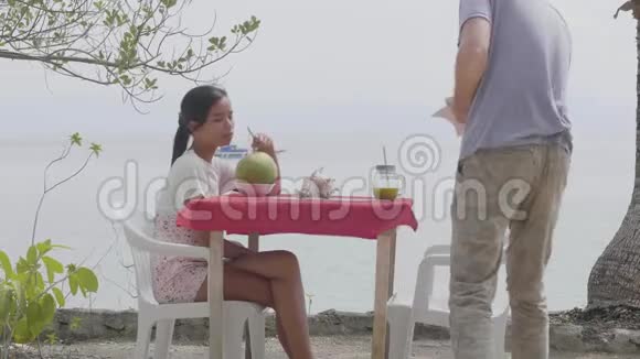 快乐的跨种族夫妇在海边的咖啡馆喝新鲜果汁视频的预览图