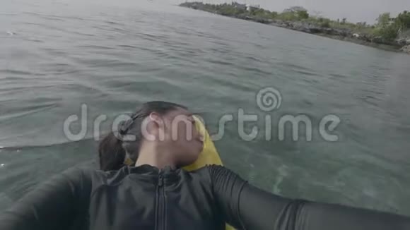 自拍一个年轻女人躺在移动的桨板皮艇上的视频视频的预览图