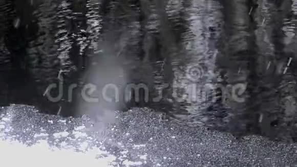 雪落在危险的水的黑暗深渊上视频的预览图