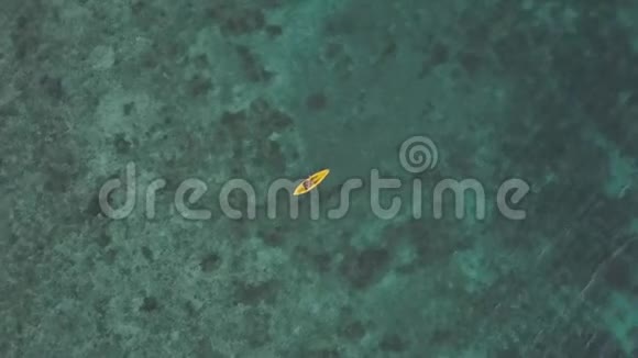 一位女性皮划艇在海上的皮划艇上冥想的鸟瞰图视频的预览图