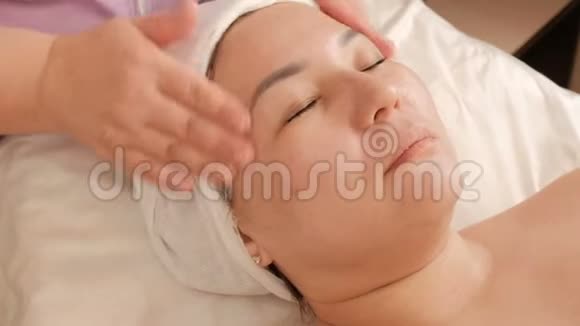 脸部按摩女性护肤在美容院的亚洲女孩健康和青年水疗中心的抗衰老治疗视频的预览图