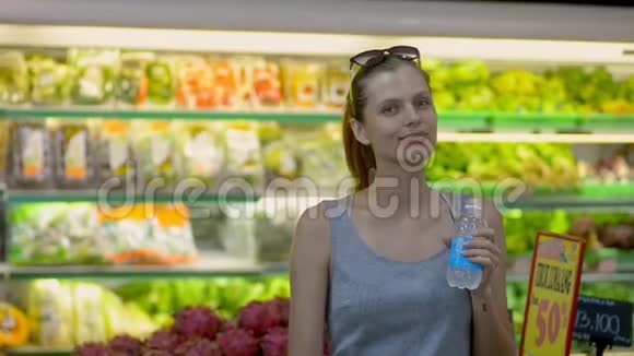 快乐的美国女人摆着水瓶站在有机商店视频的预览图