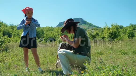 两个女孩旅行者用手表看时间用手机在山上建造一条路线视频的预览图