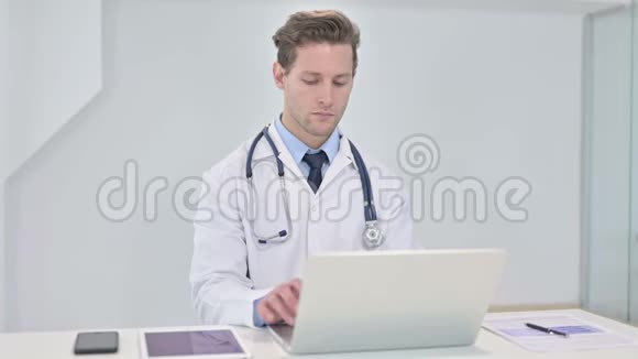 开朗的年轻医生在办公室做电脑聊天视频的预览图