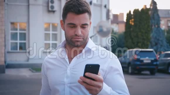 站在城市街道上的年轻人在他的智能手机上打字穿着智能手机的漂亮商人视频的预览图