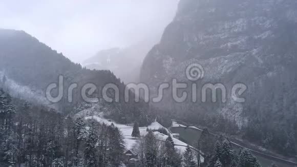 在冬天雾蒙蒙的一天飞越瑞士山区的山谷视频的预览图