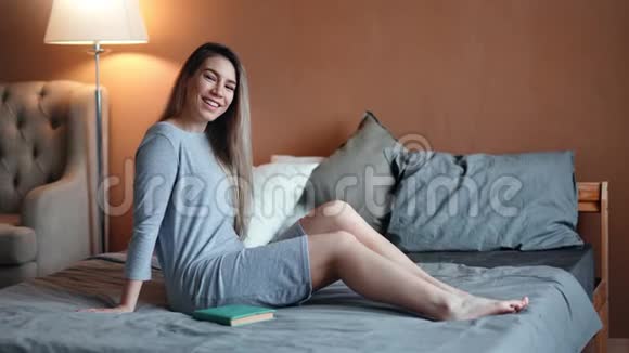 在舒适的公寓内部坐在床上享受乐趣享受免费的快乐休闲女士视频的预览图