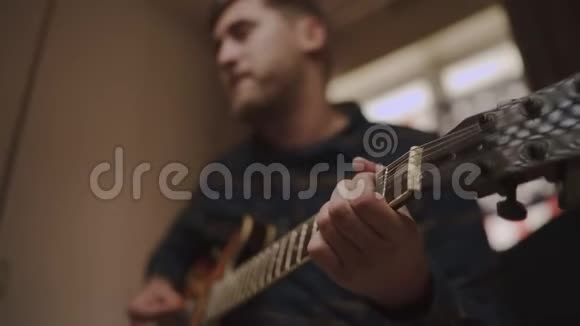 年轻男子在家中弹声吉他重点放在手和头架上视频的预览图