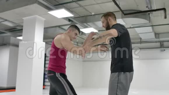 两名摔跤手动作缓慢希腊罗马摔跤手穿着T恤衫和外套在大厅里训练视频的预览图
