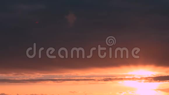 阳光透过日落的天空明亮的天空与蓬松的云黄色橙色蓝色和洋红色黎明视频的预览图