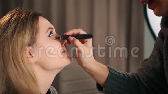 专业的亚洲化妆师化妆使用毛毡尖笔遮瑕器来去除该属的瘀伤视频的预览图