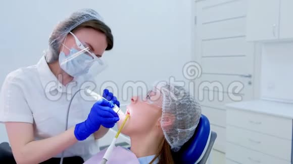 牙科保健员为牙科年轻妇女做超声波牙齿清洁视频的预览图