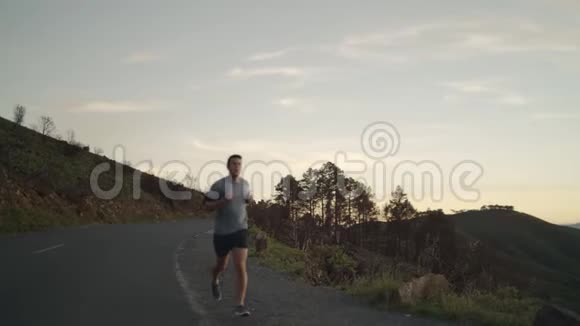 在慢跑训练中在山路上跑步休息呼吸的精疲力竭的年轻人精疲力竭视频的预览图