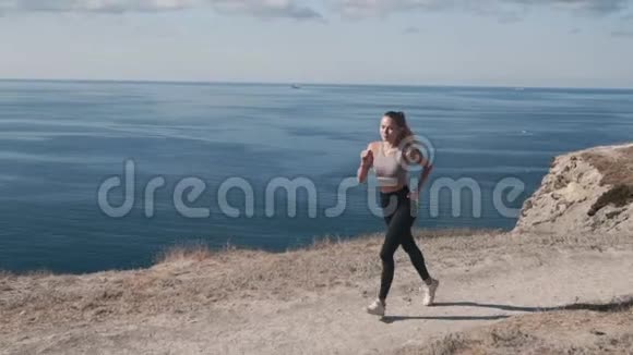 女性在户外跑步的背面美丽的海景慢动作视频的预览图