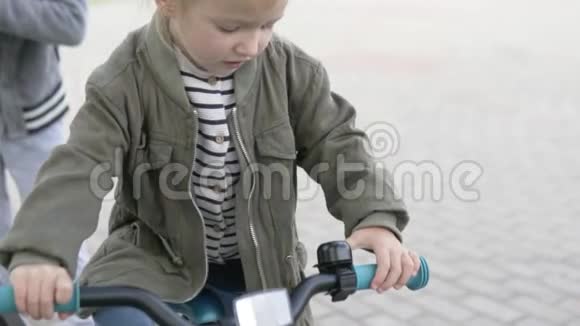 小女孩在自行车上按铃视频的预览图