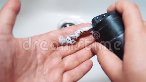 一个男人用刮胡胶贴在他的手上视频的预览图