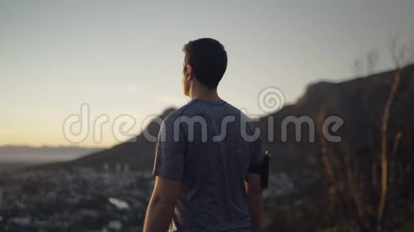 一个年轻的跑步者站在山顶上享受日出的多利照片鼓舞人心视频的预览图
