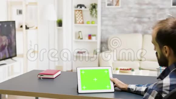 放大手持绿色屏幕数字平板电脑的人的镜头视频的预览图