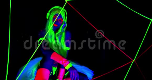 在紫外线下性感的女人在黑暗明亮的颜色和灯光下发光视频的预览图