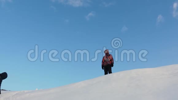 旅行者在雪地上攀登胜利在山顶相遇冬天的游客作为团队一起工作视频的预览图
