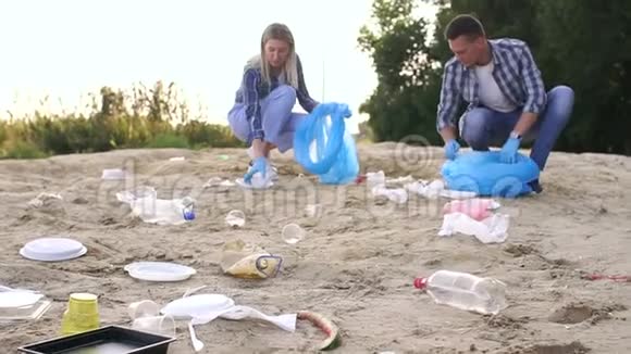 特写一组志愿者在沙滩上收集塑料垃圾视频的预览图