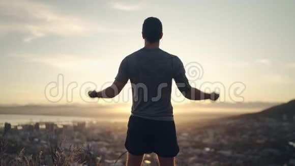 一位运动健康的男性运动员用紧握的拳头伸展双手以庆祝他在比赛中的成功视频的预览图