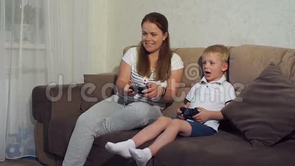 男孩和母亲坐在沙发上在电视上玩动作游戏视频的预览图