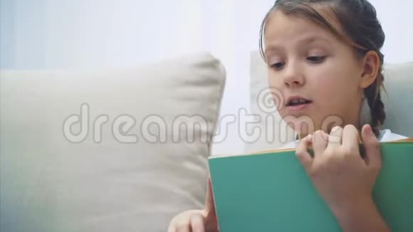歪歪扭扭的可爱的小女孩坐着读着童话般的情感绝望地挥动着她的手视频的预览图