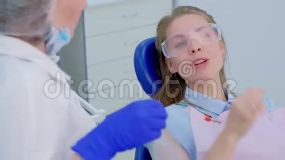 病人妇女在口腔诊所向牙医谈论她的牙齿问题视频的预览图