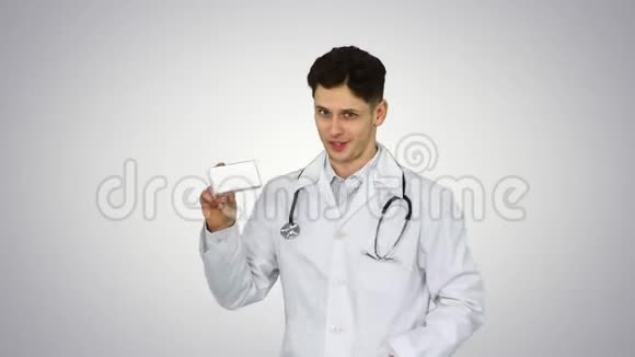 医生拿着一盒药丸在梯度背景下促进它们并跳舞视频的预览图