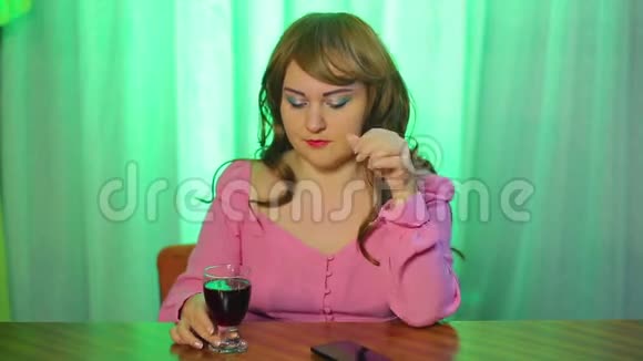 红发少女看着手机手里拿着一杯红酒视频的预览图