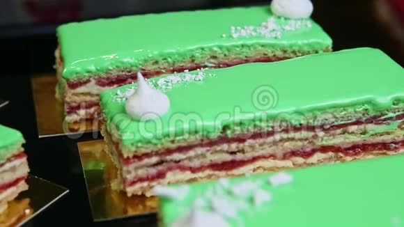 在金色看台上提供的绿色釉面分层蛋糕部分的特写全景视频的预览图