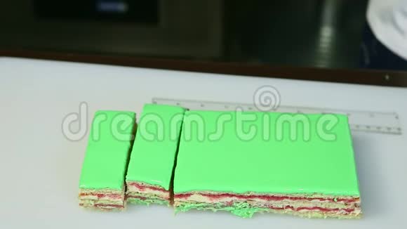 特写切片部分绿色釉层蛋糕与奶油水果馅视频的预览图