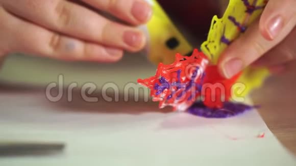 一个男孩的手特写创造了一朵塑料花他用的是3D笔视频的预览图