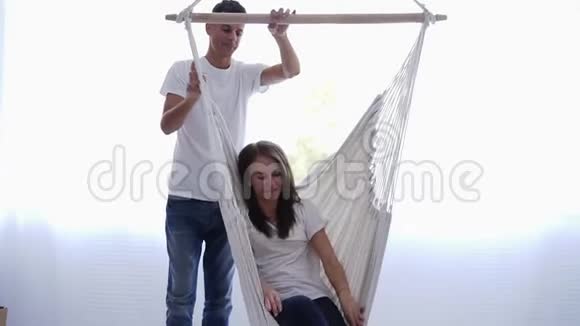 可爱的白种人丈夫安慰摆动他的妻子两人一起享受休闲女孩躺在吊床里视频的预览图