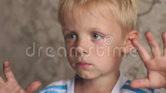 一个小男孩的特写肖像他的脸很脏手很脏视频的预览图