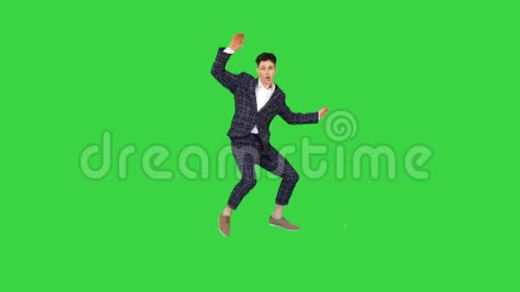 年轻迷人的男舞者穿着严格的商务套装在绿色屏幕上跳舞Chroma键视频的预览图