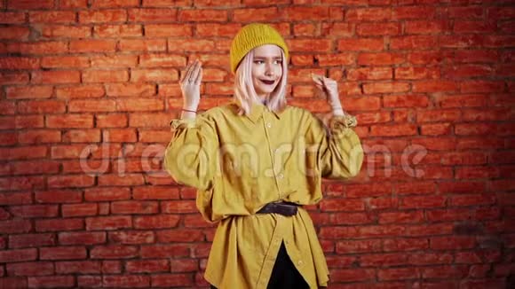 迷人的不寻常的女人粉红色的头发黄色的显示了blabla的手势视频的预览图