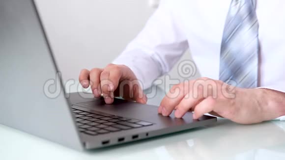 在键盘笔记本电脑上合上人手打字男士商务办公服白衬衫和领带文本视频的预览图