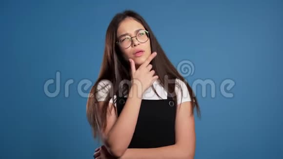 思考女人在蓝色背景上抬头看了看担心沉思的面部表情漂亮的亚洲女孩模特视频的预览图