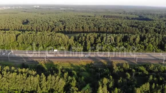 夏季日落时沿森林高空俯瞰铁路4k景观视频的预览图