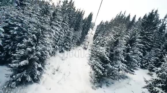 滑雪电梯上雪林的人视频的预览图