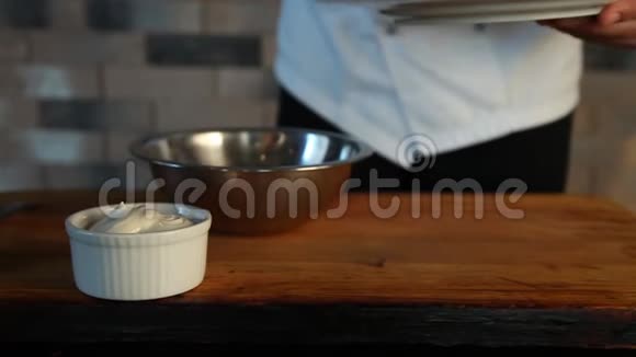 厨师做俄罗斯沙拉他把切片的原料放在碗里和蛋黄酱混合特写镜头视频的预览图