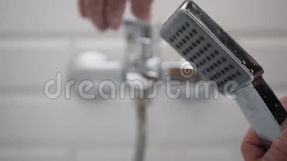 男子开放浴室水龙头和淋浴头视频的预览图