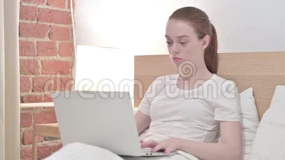 勤劳的红发青年女子在笔记本电脑上失败视频的预览图