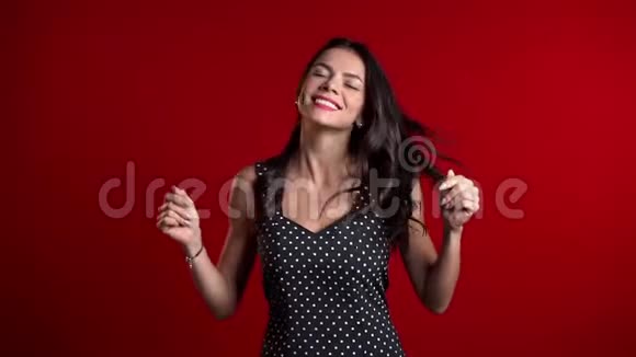 迷人的性感女人微笑和跳舞的红色工作室背景视频的预览图