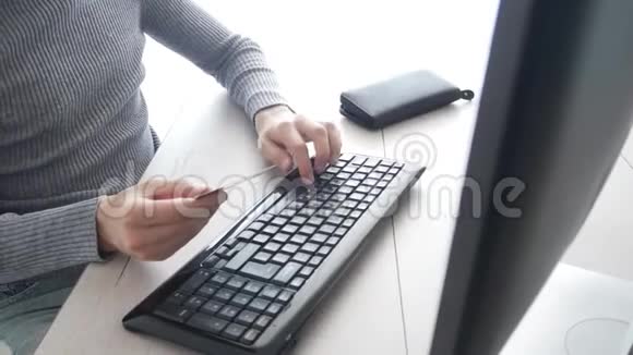用信用卡在线支付购物男性在通过互联网购物时使用信用卡计算机视频的预览图