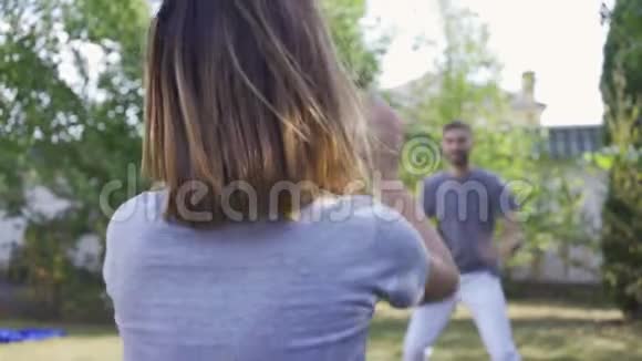 后景年轻人和妻子在户外打球积极的休闲快乐的一对夫妇在避暑别墅休息视频的预览图